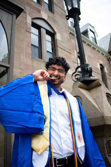 A man in a blue robe talking on a cell phone