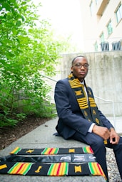A man in a suit and tie sitting on a bench