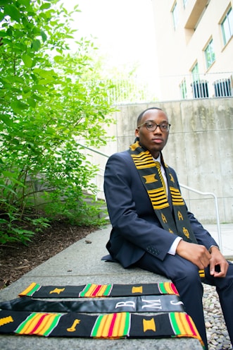 A man in a suit and tie sitting on a bench