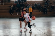 A group of people playing a game of basketball