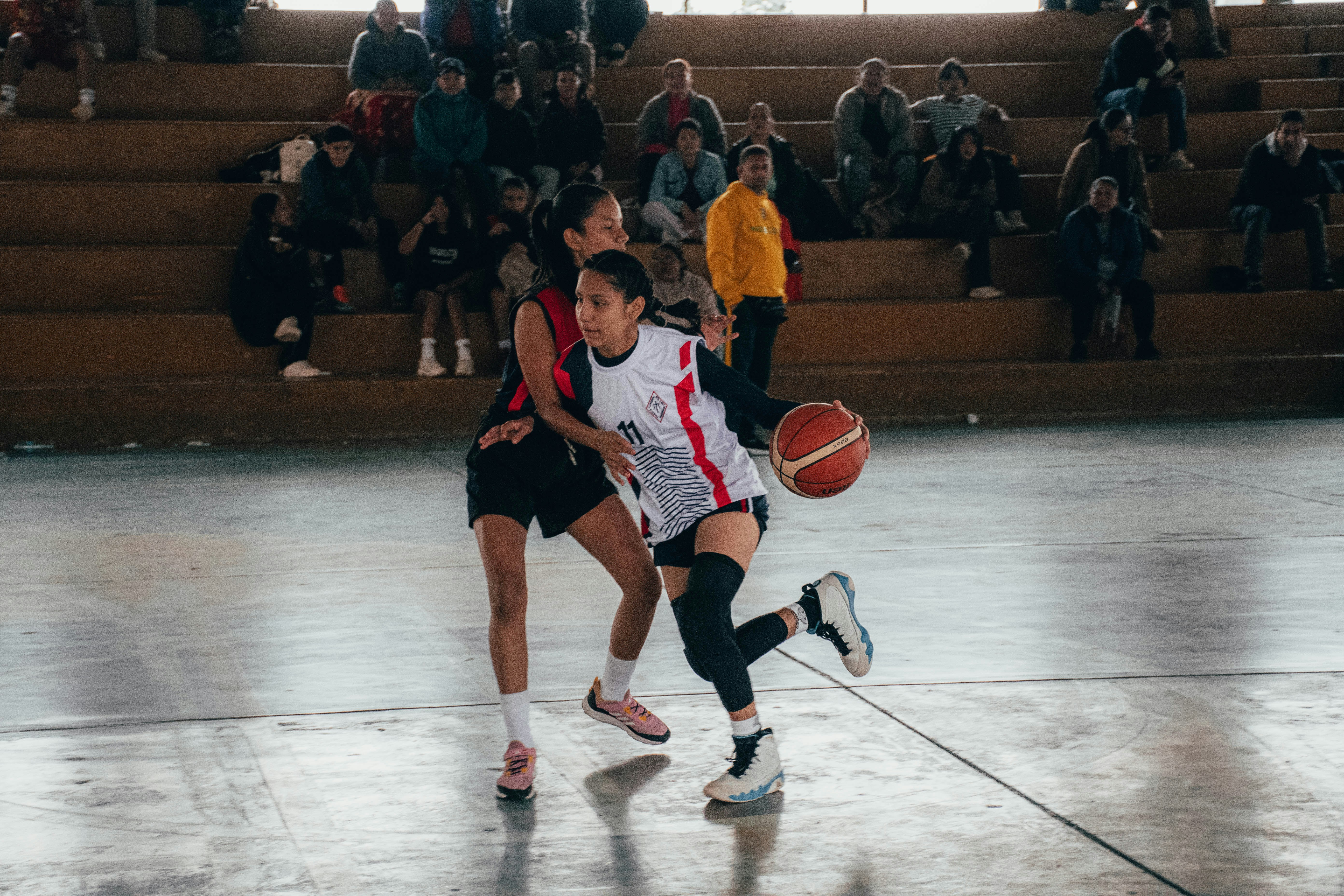 A group of people playing a game of basketball