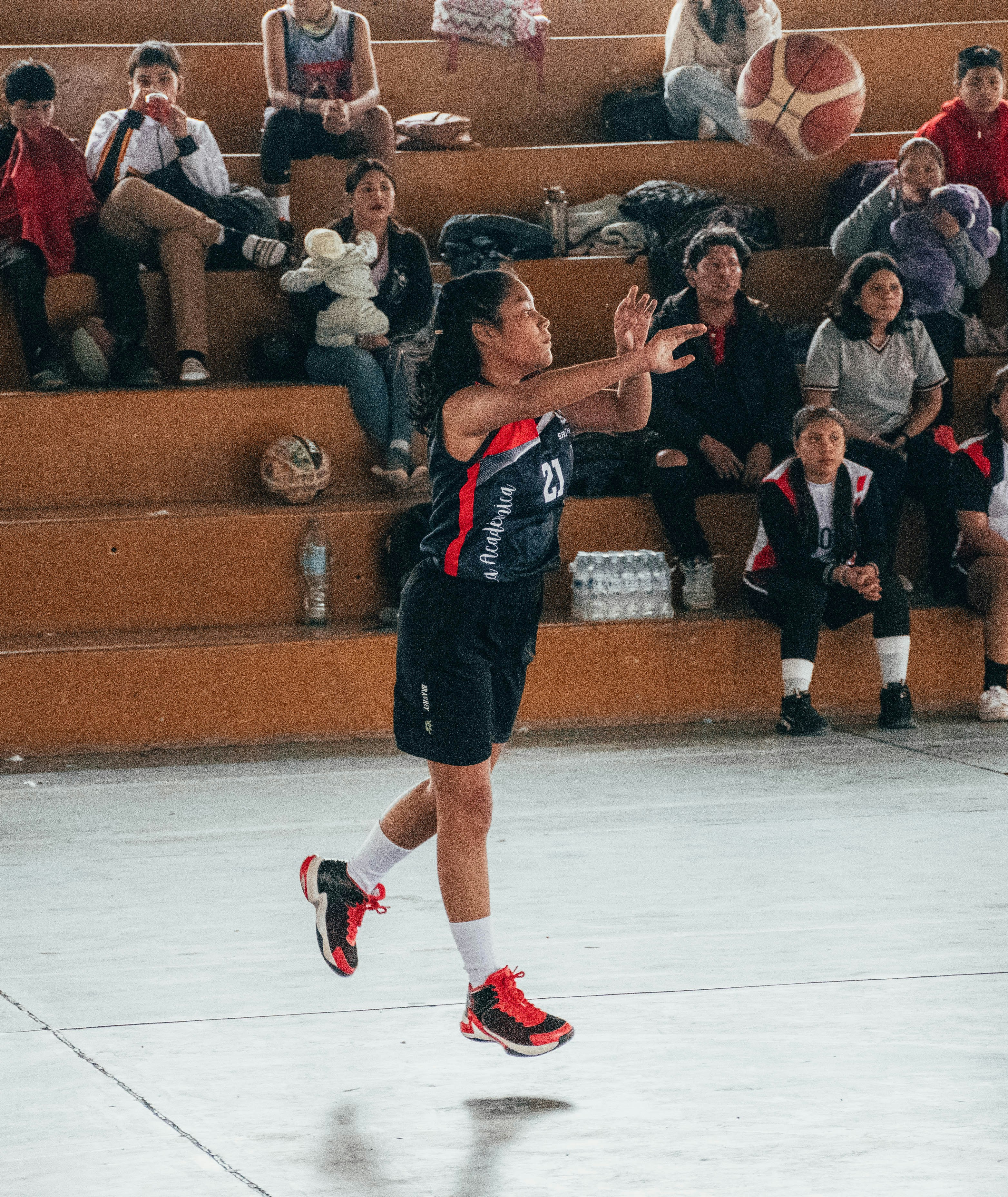 A person jumping up in the air to hit a basketball