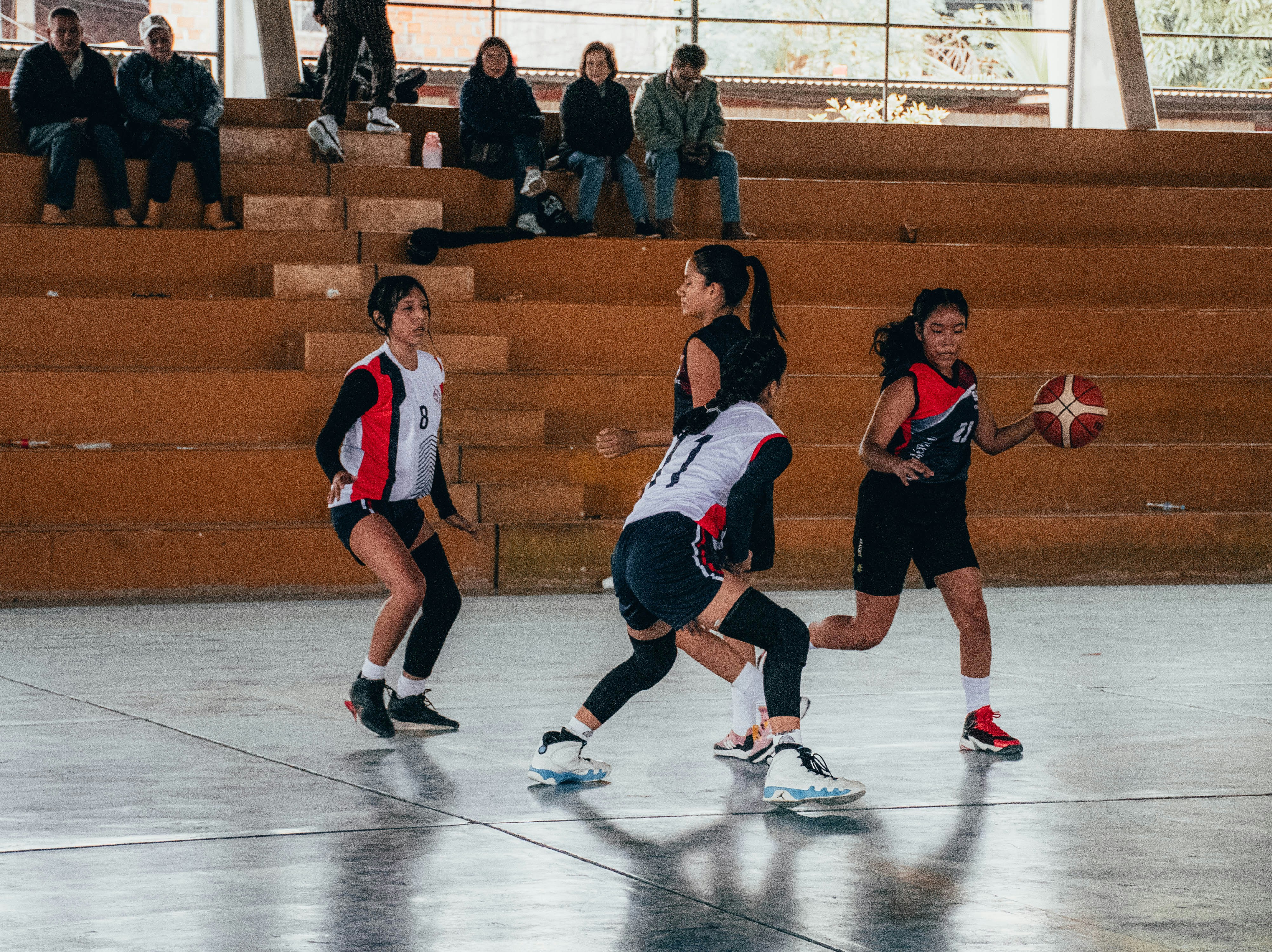 A group of people playing a game of basketball