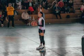 A woman standing on a basketball court holding a basketball