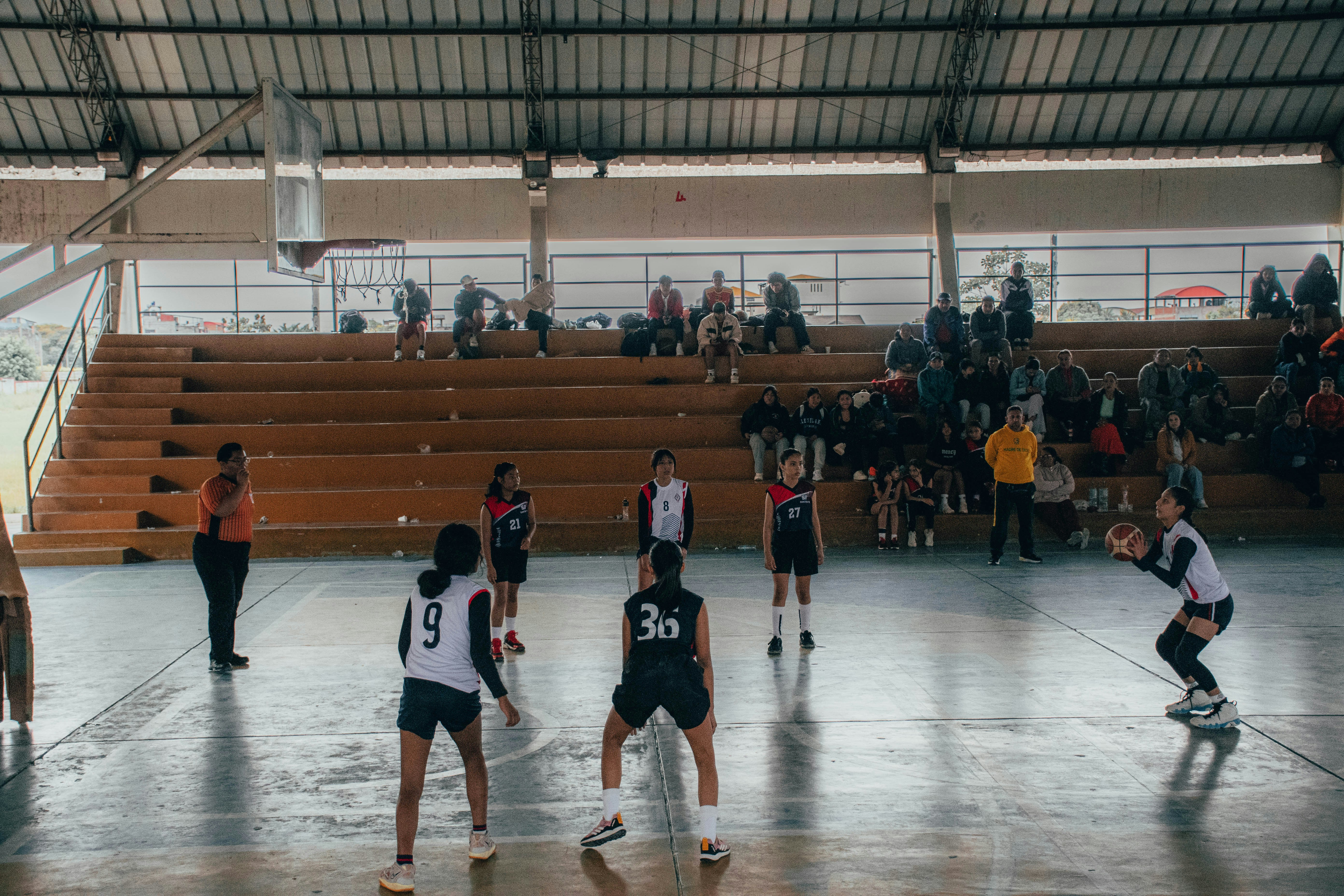 Acción de un partido de vóley en coliseo con bloqueo en la red