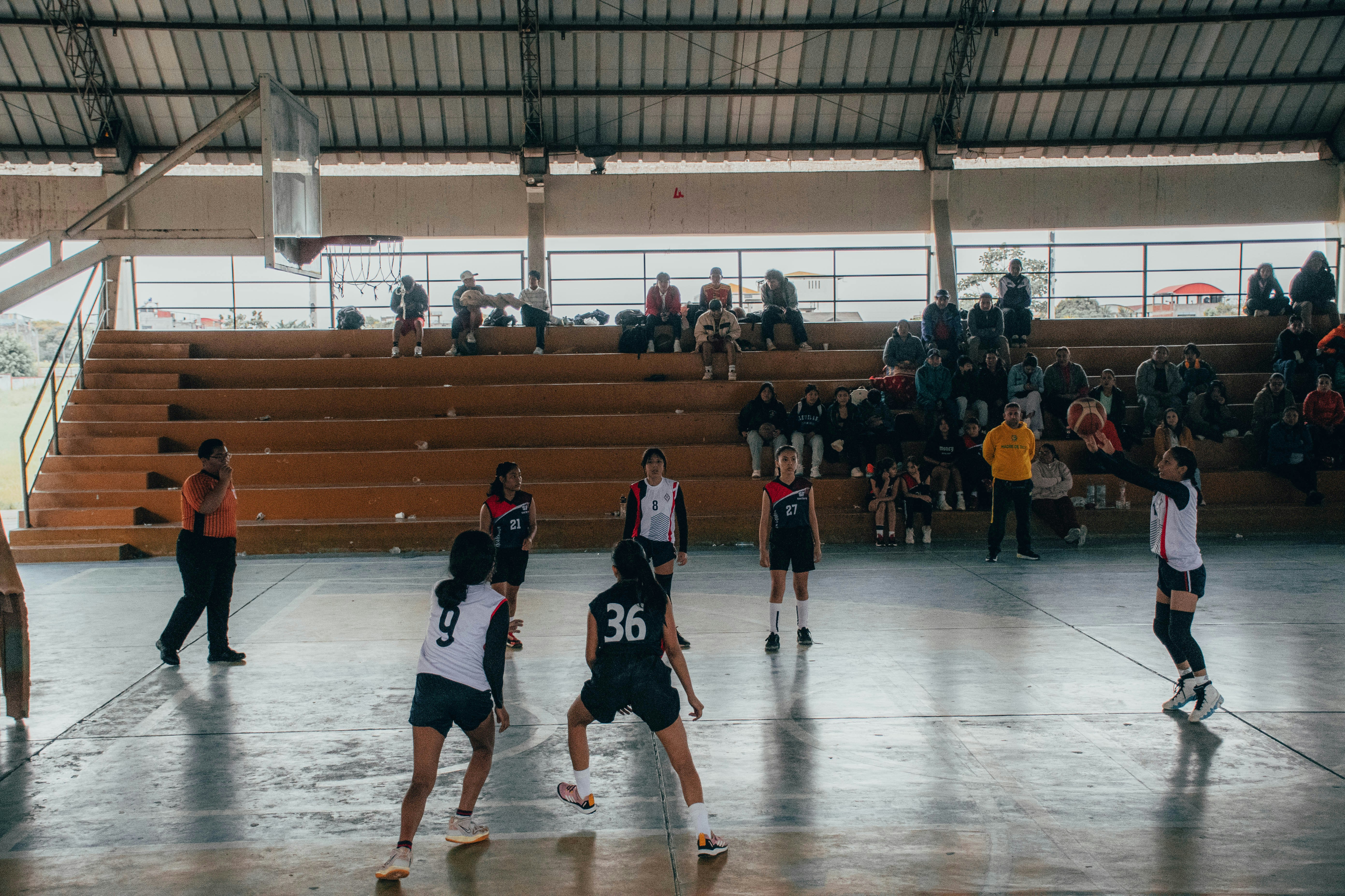 Jugadoras disputando un punto en un coliseo de vóley