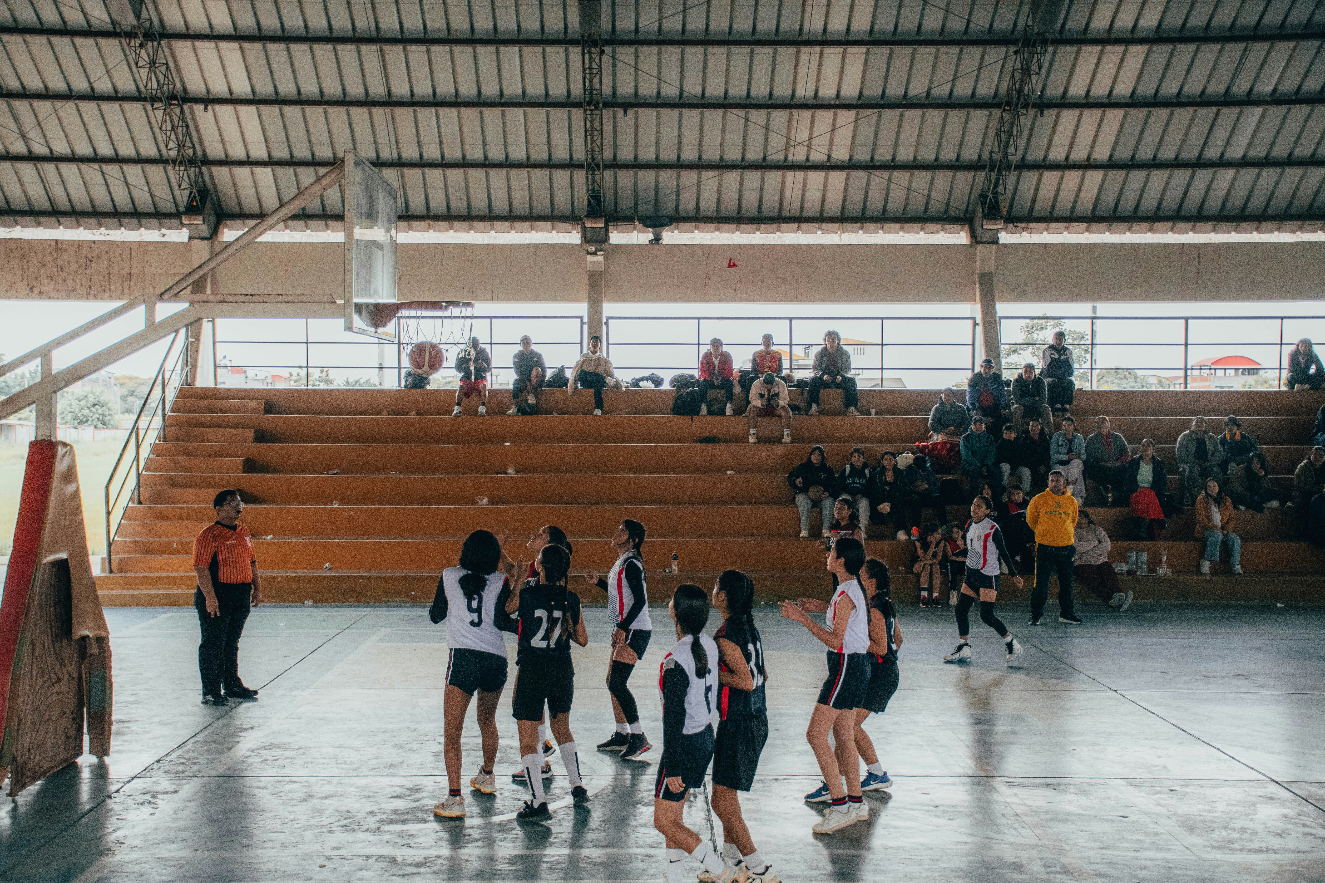 A group of young people playing a game of basketball
