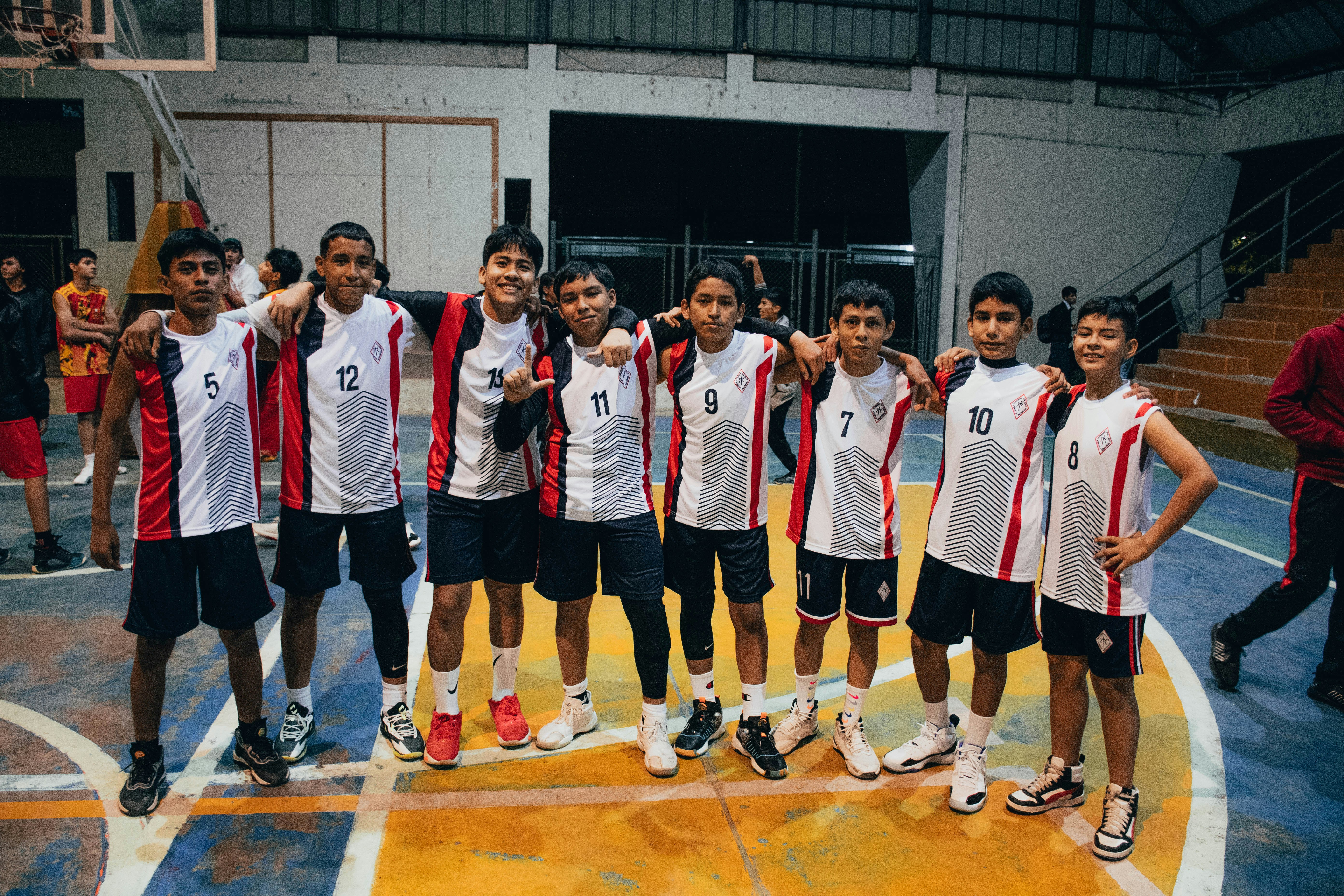 A group of young men standing on top of a basketball court