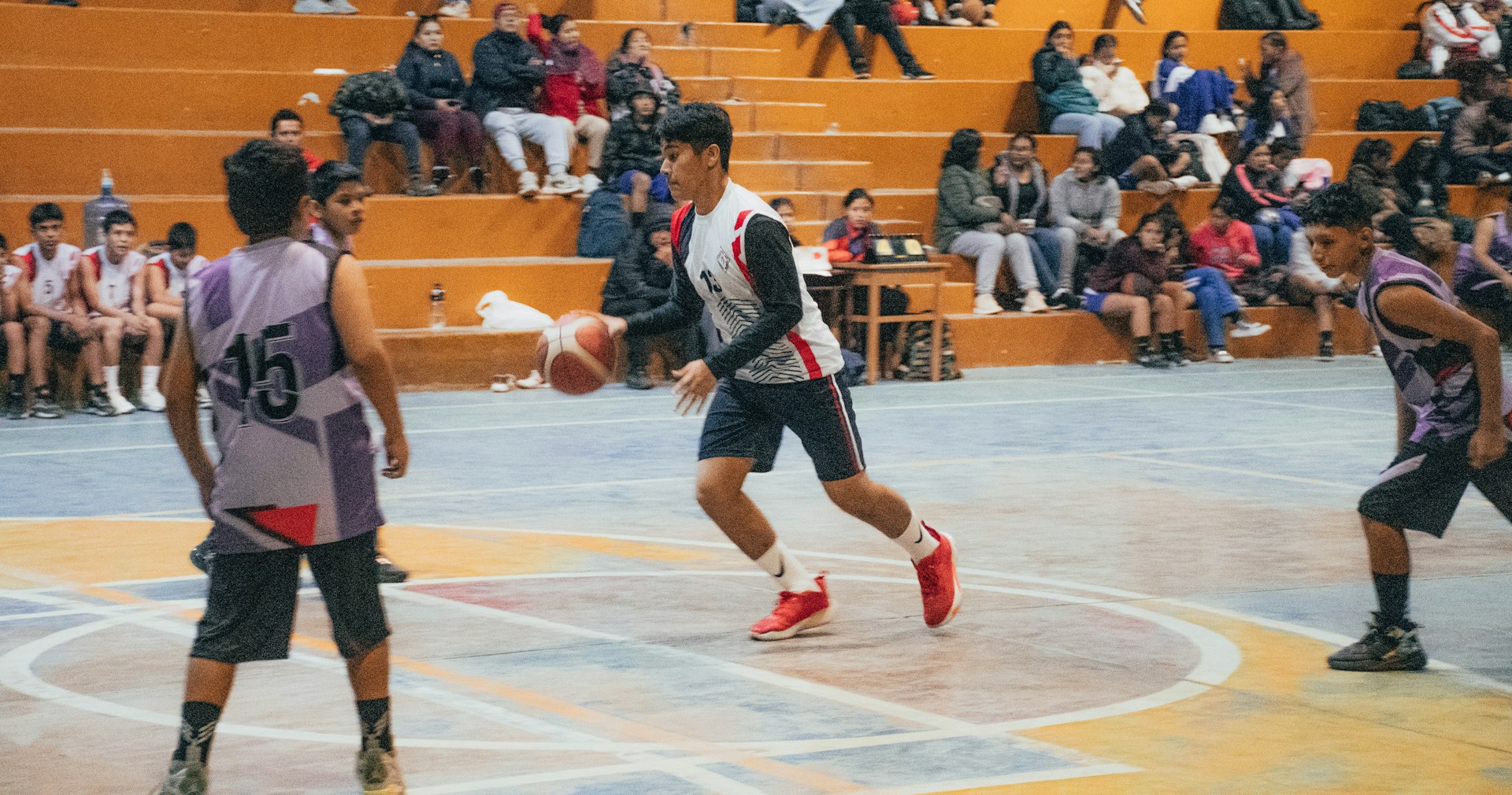 A group of young men playing a game of basketball