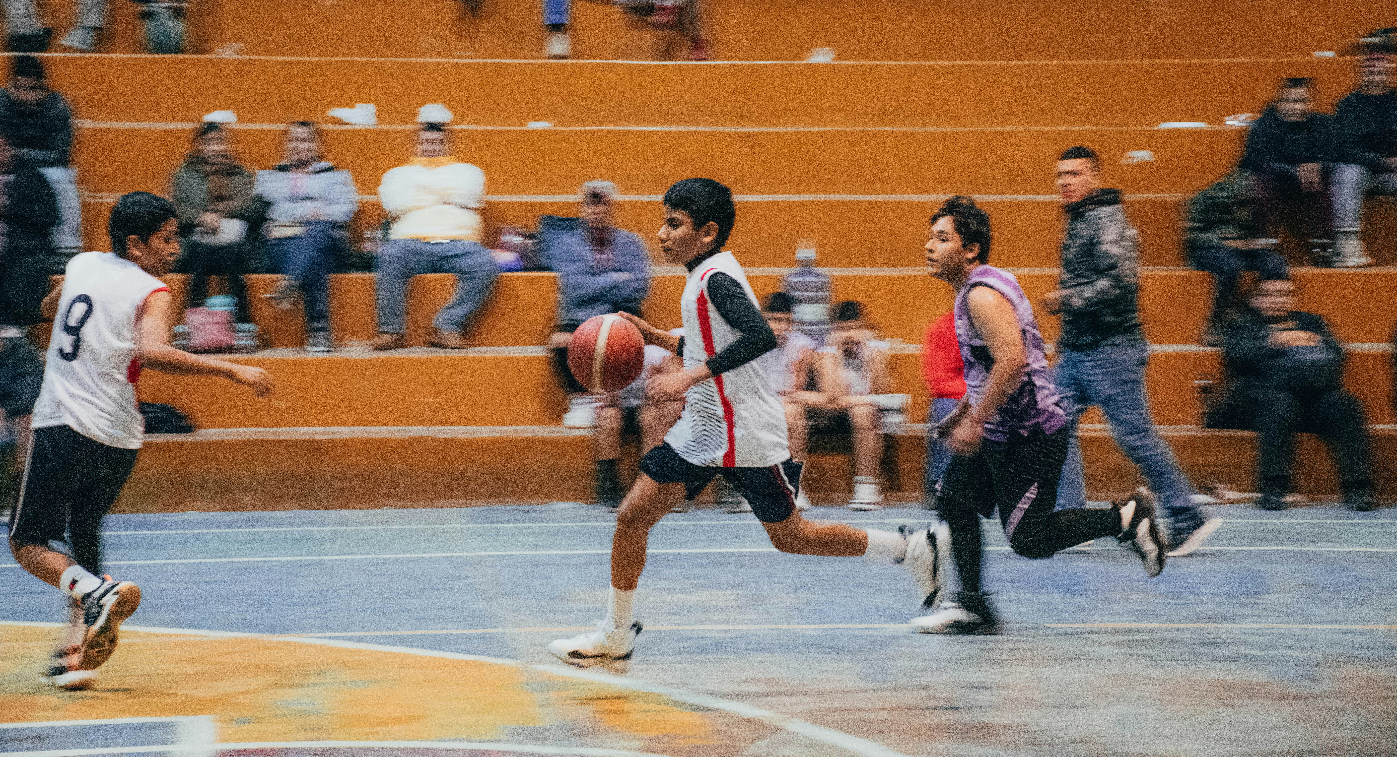 A group of young men playing a game of basketball