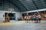 A group of men standing around a basketball court