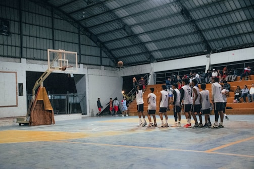 A group of men standing around a basketball court