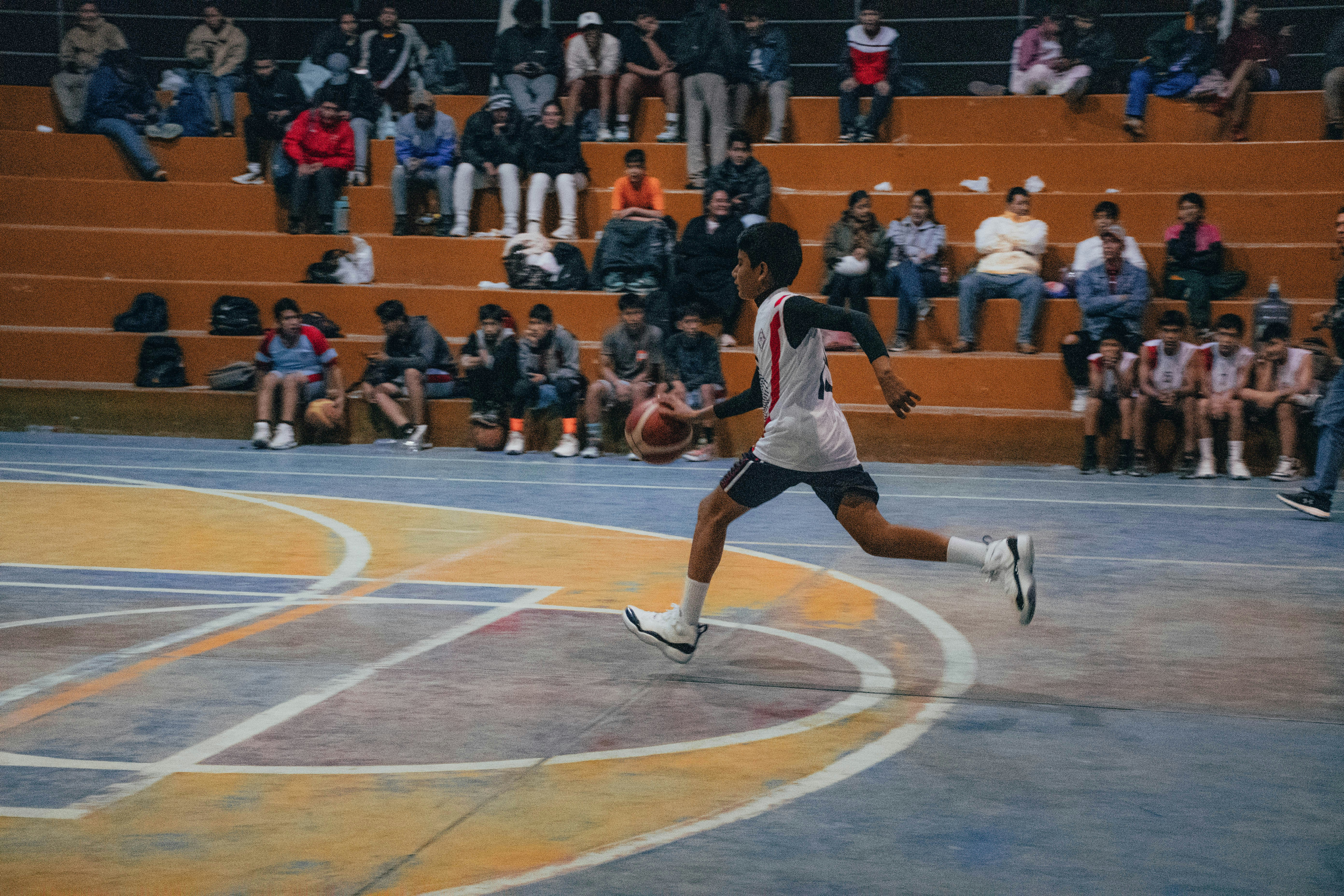 A man is running on a basketball court