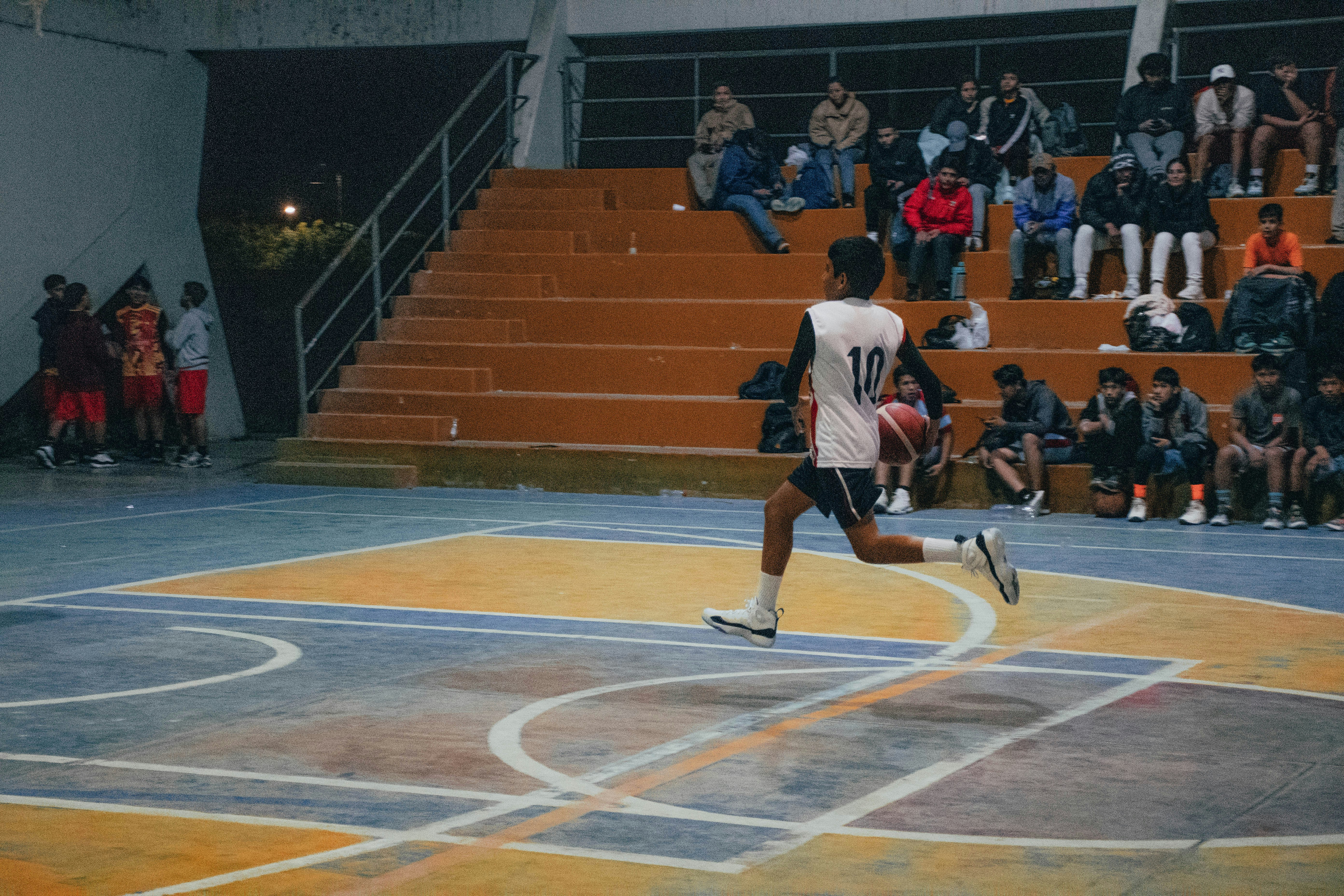 A man is running on a basketball court