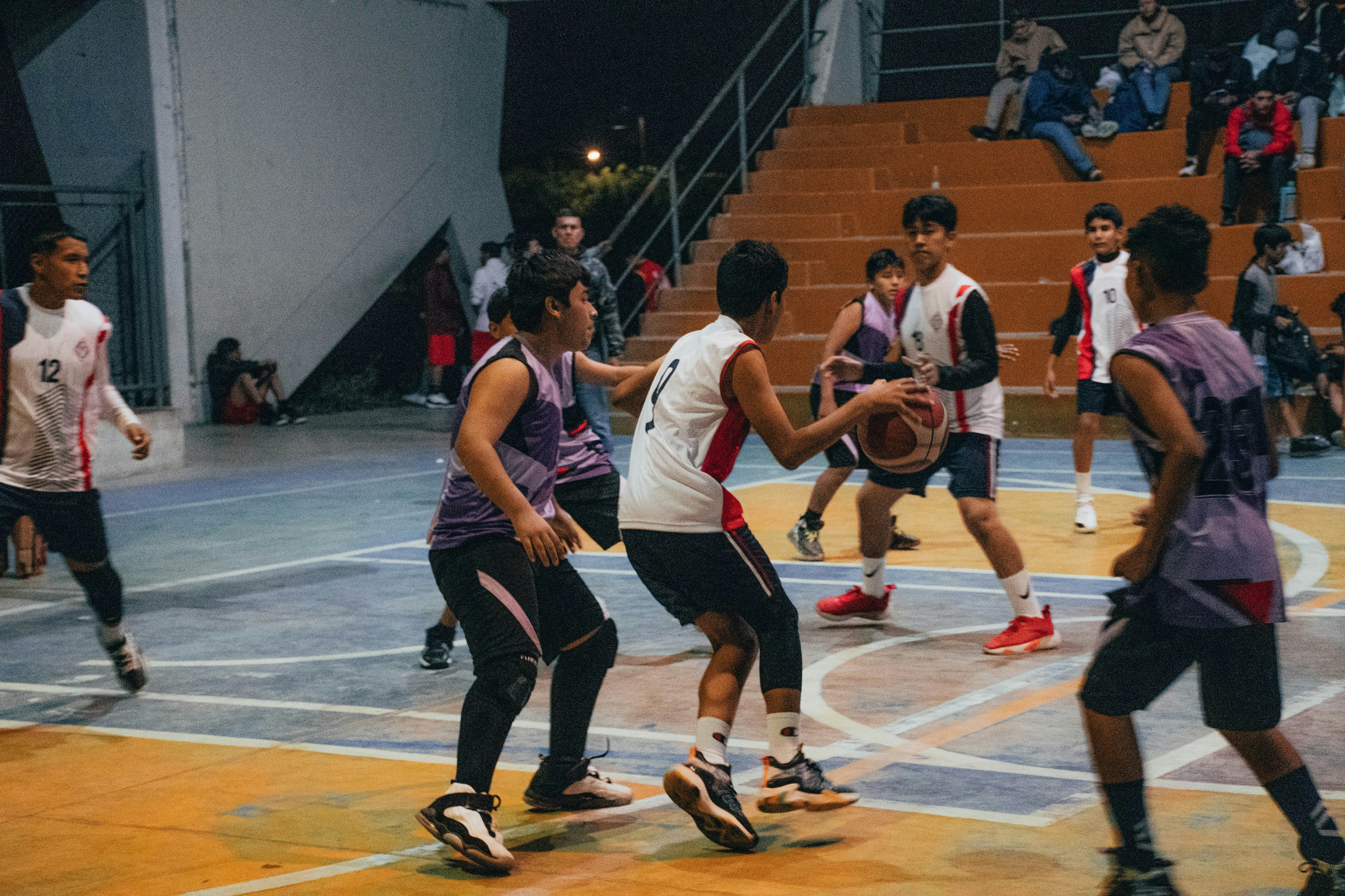 A group of young men playing a game of basketball