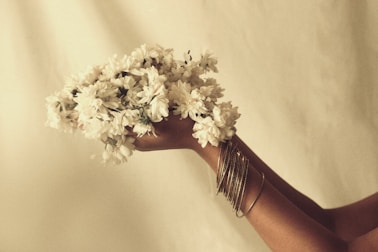 A woman holding a bunch of flowers in her hand