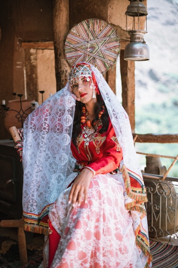 A woman in a red and white dress sitting on a chair