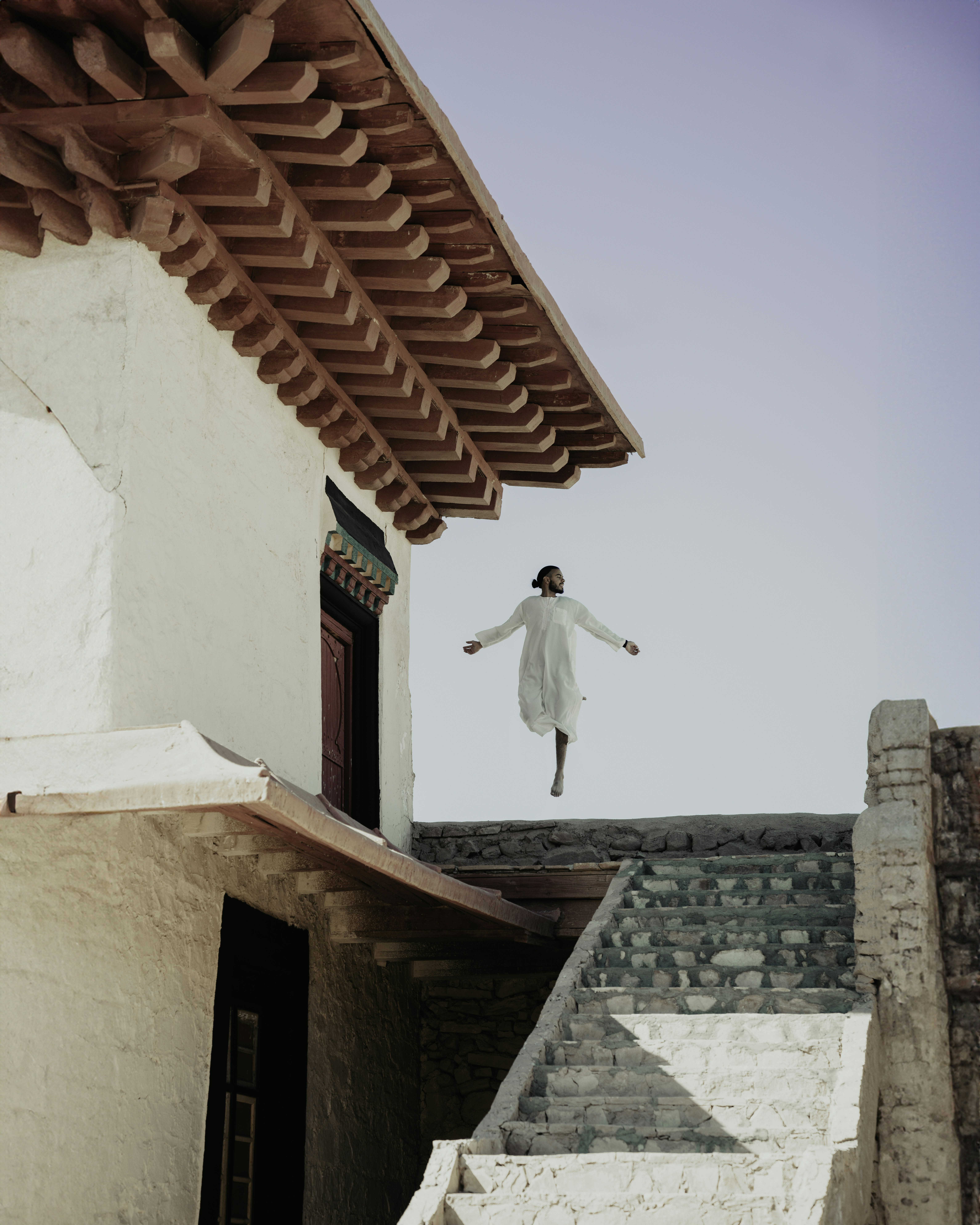 A person jumping in the air from a building