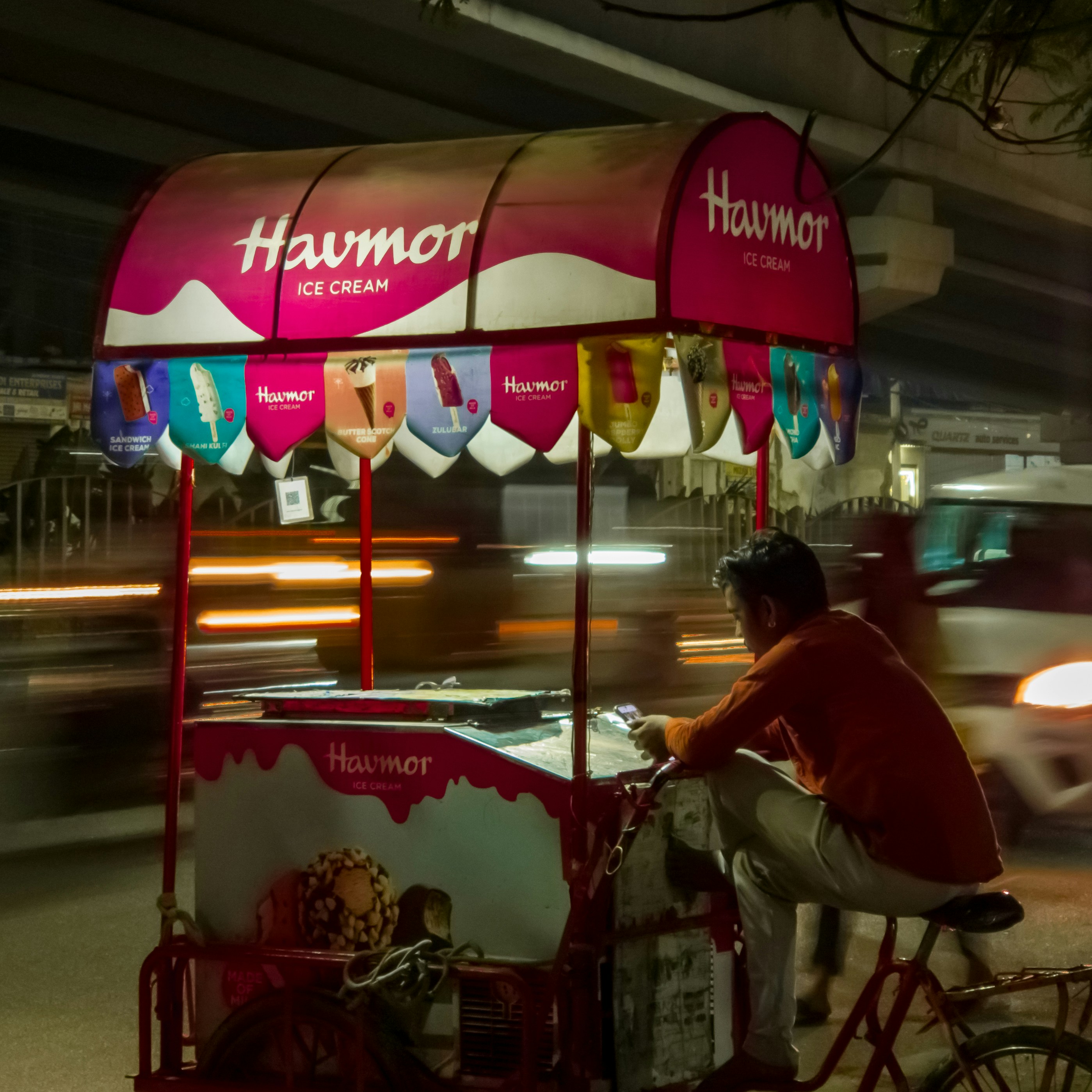 A man riding a bike next to a food cart