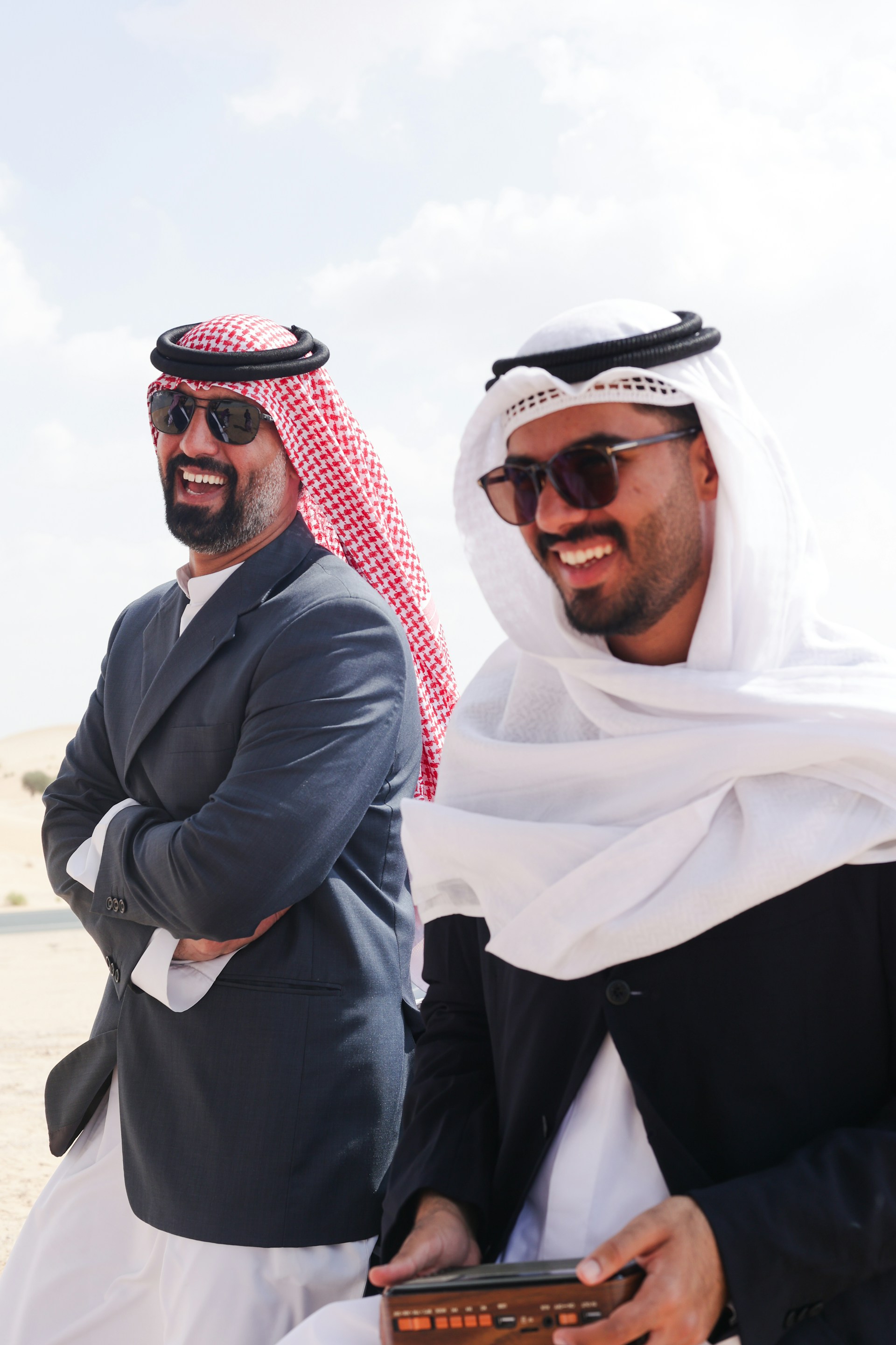 A couple of men standing next to each other on a beach
