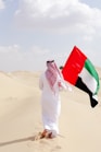 A man holding a flag in the desert