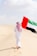 A man walking in the desert holding a flag