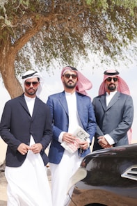 A group of men standing next to a car