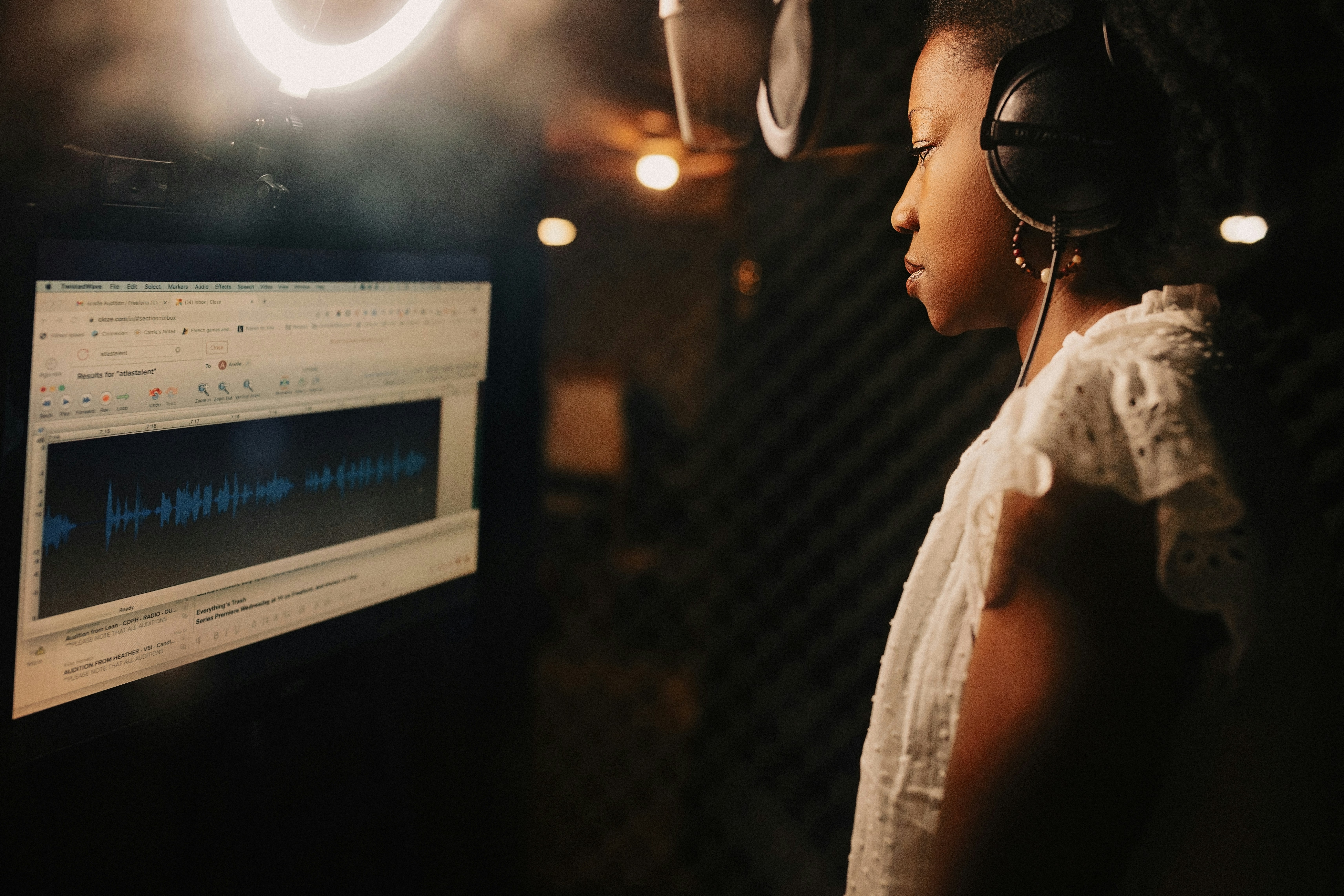 A woman wearing headphones in a recording studio