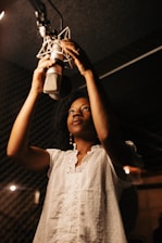 A woman in a recording studio holding a microphone