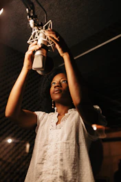 A woman in a recording studio holding a microphone