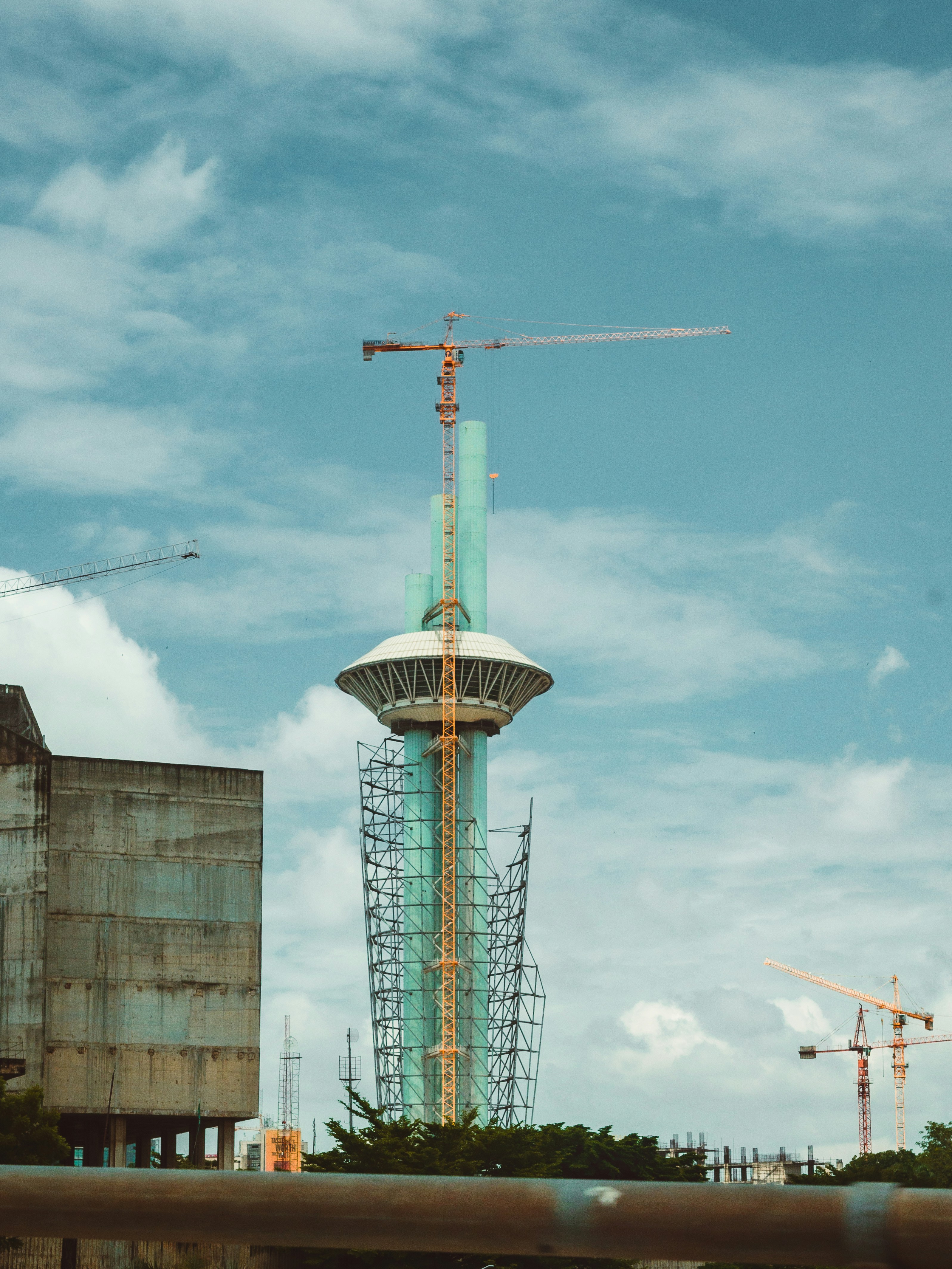 A tall tower with a crane on top of it
