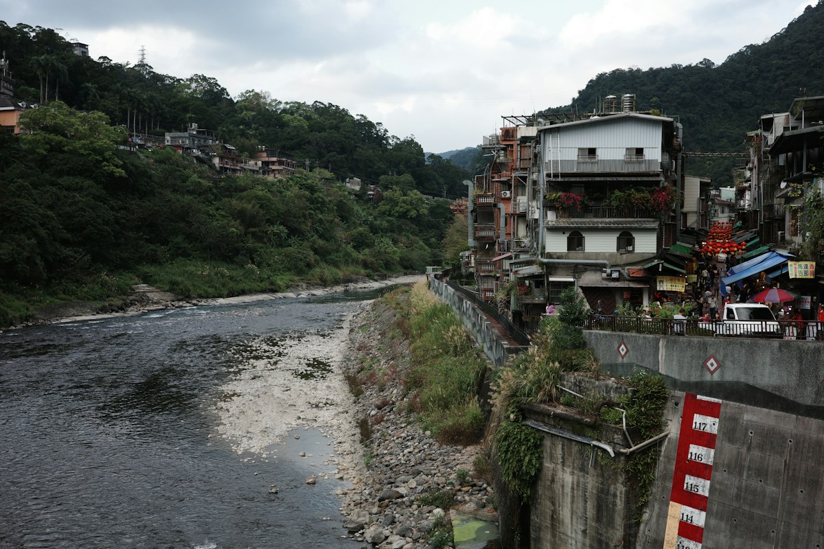 新北烏來老街沿著南勢溪岸而建，溪谷兩側是綠色山林