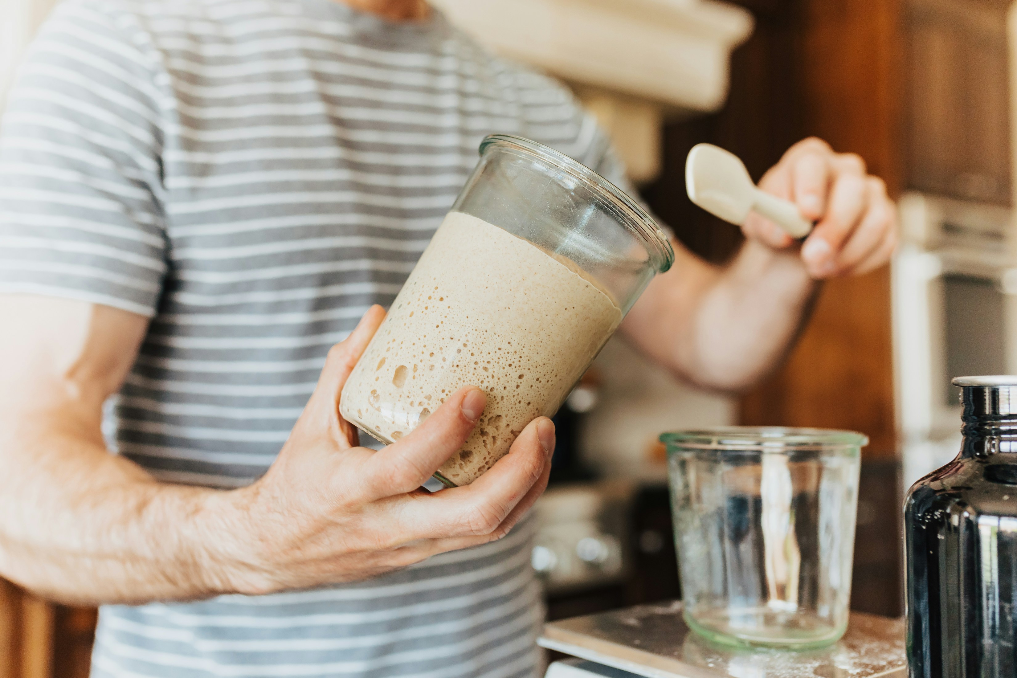 A man holding a blender in a kitchen
