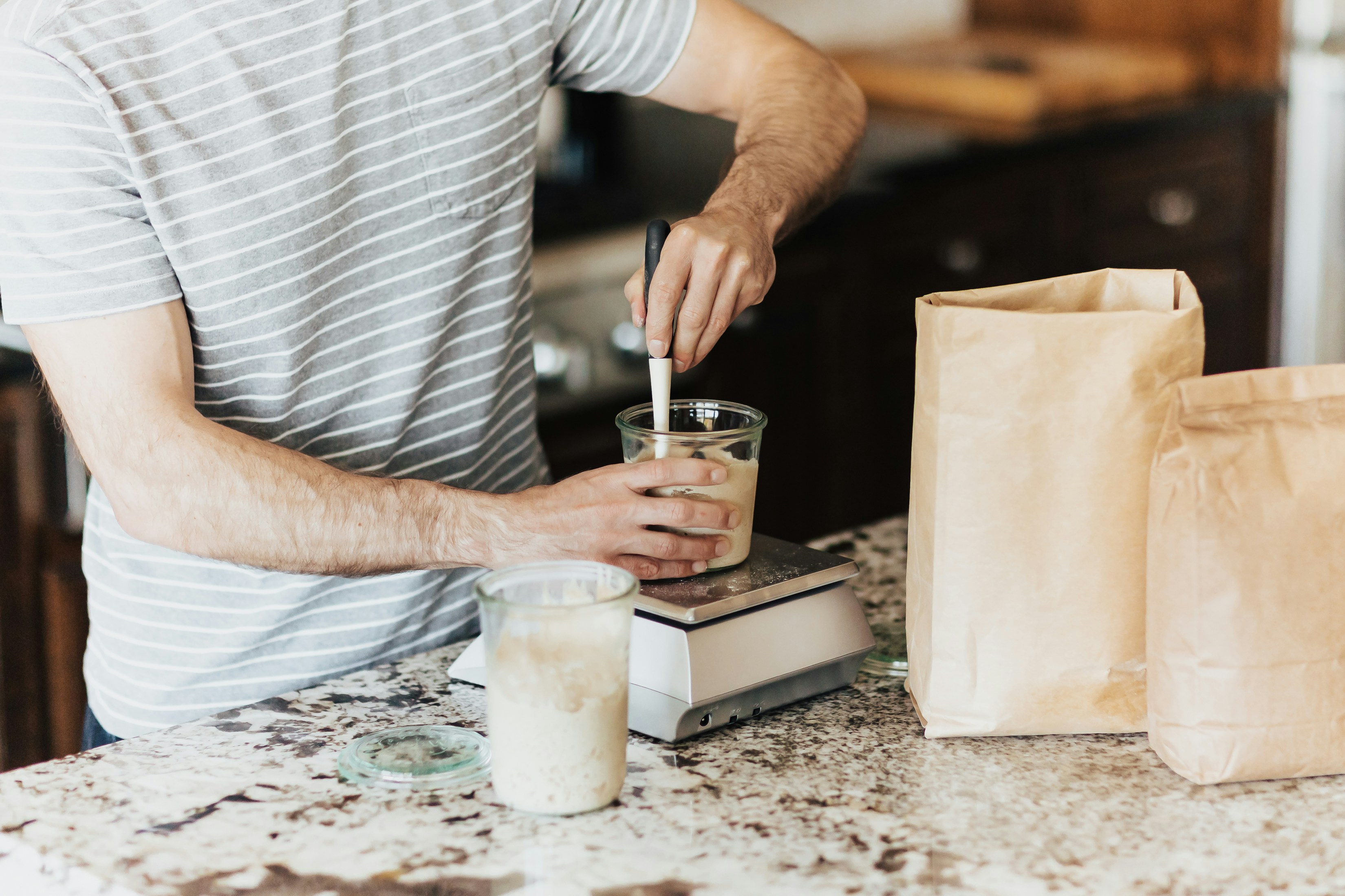 A man is making a smoothie in a kitchen