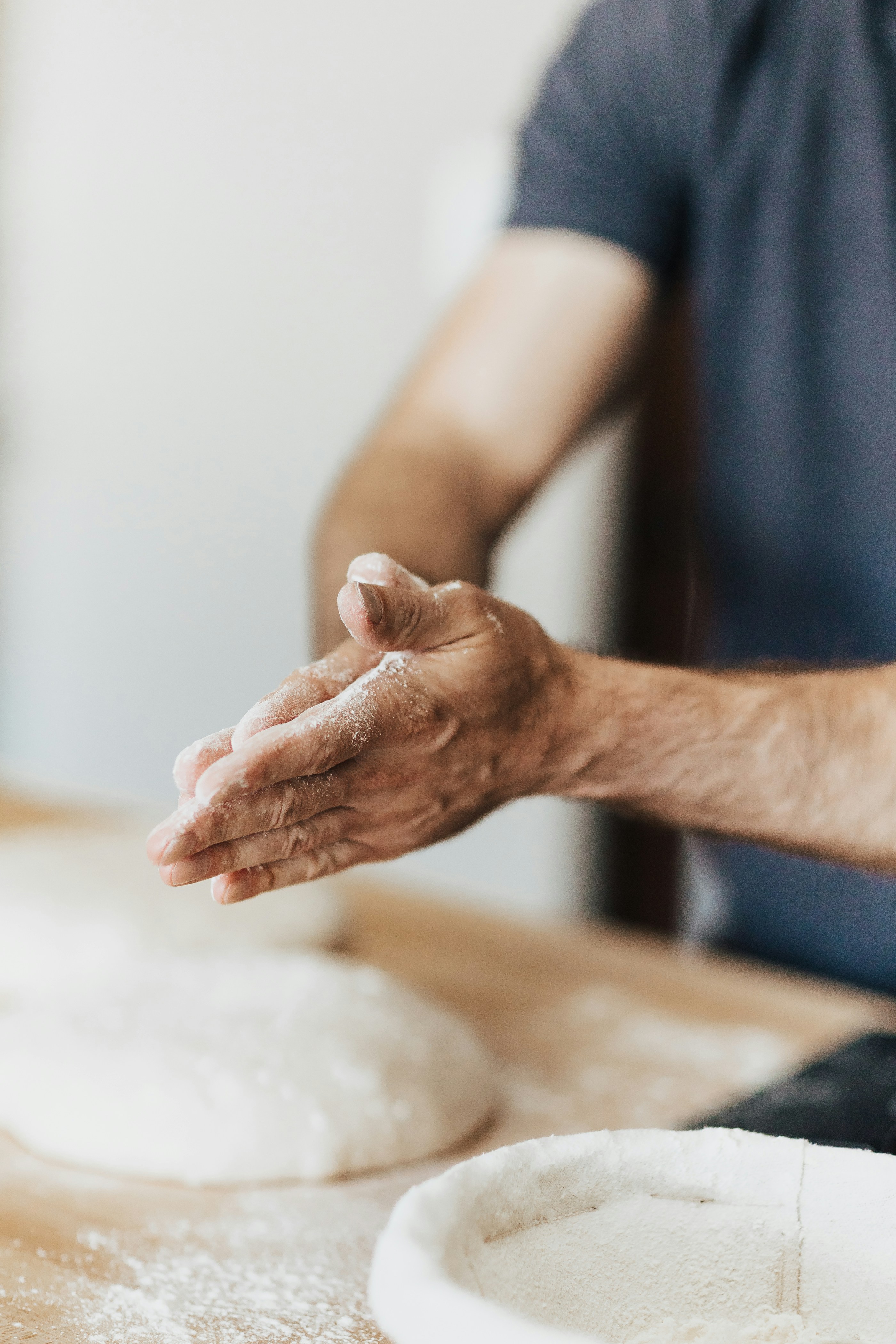 A man is kneading dough on a table