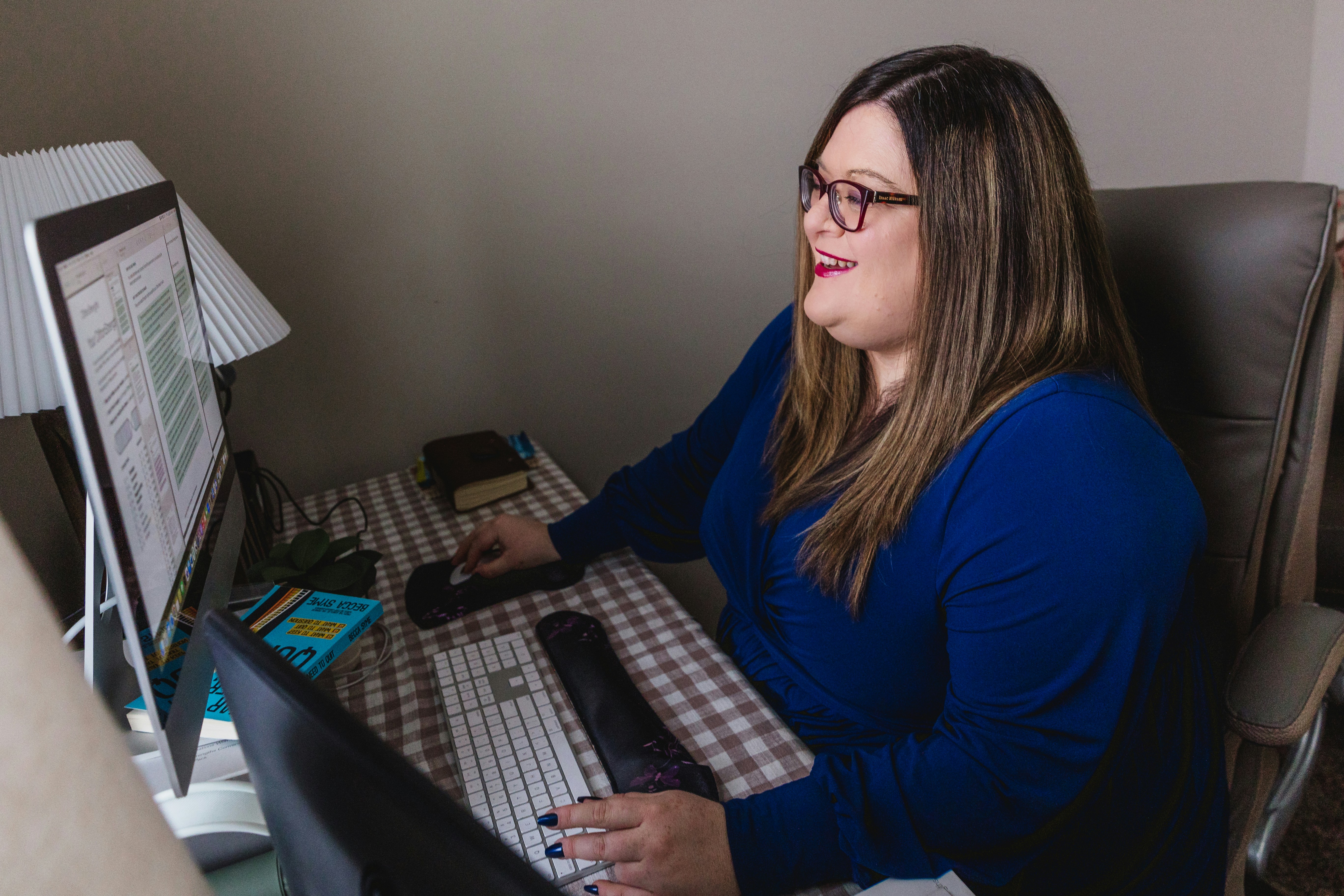 A woman sitting at a desk in front of a computer