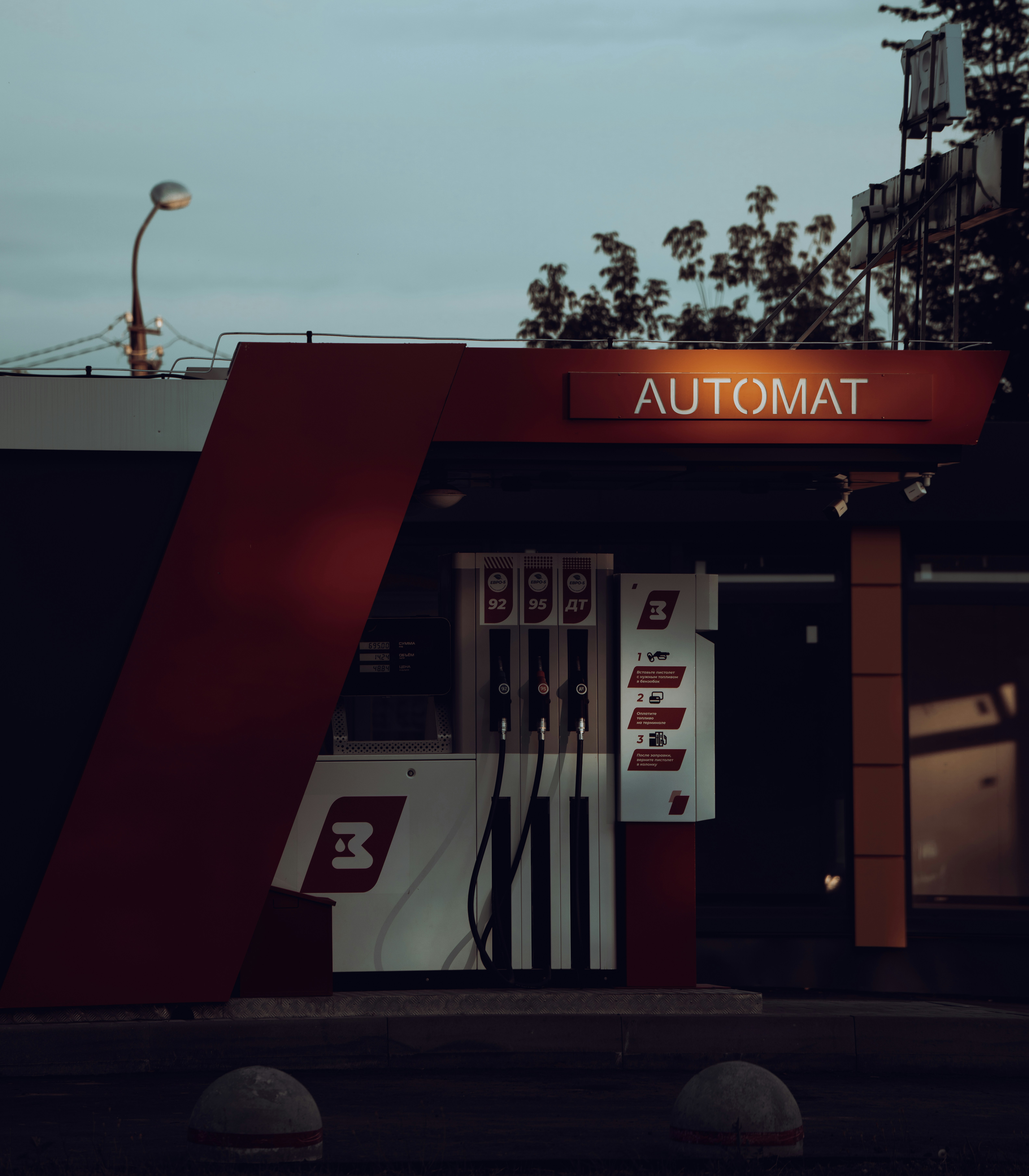 A red and white gas station sitting next to a tall building