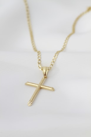 A gold necklace with a cross on it