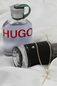 A bottle of perfume sitting on top of a bed