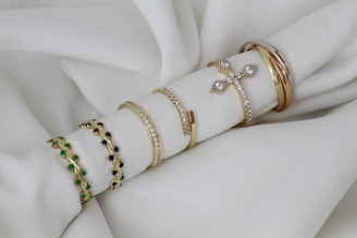 A close up of a stack of bracelets on a white cloth
