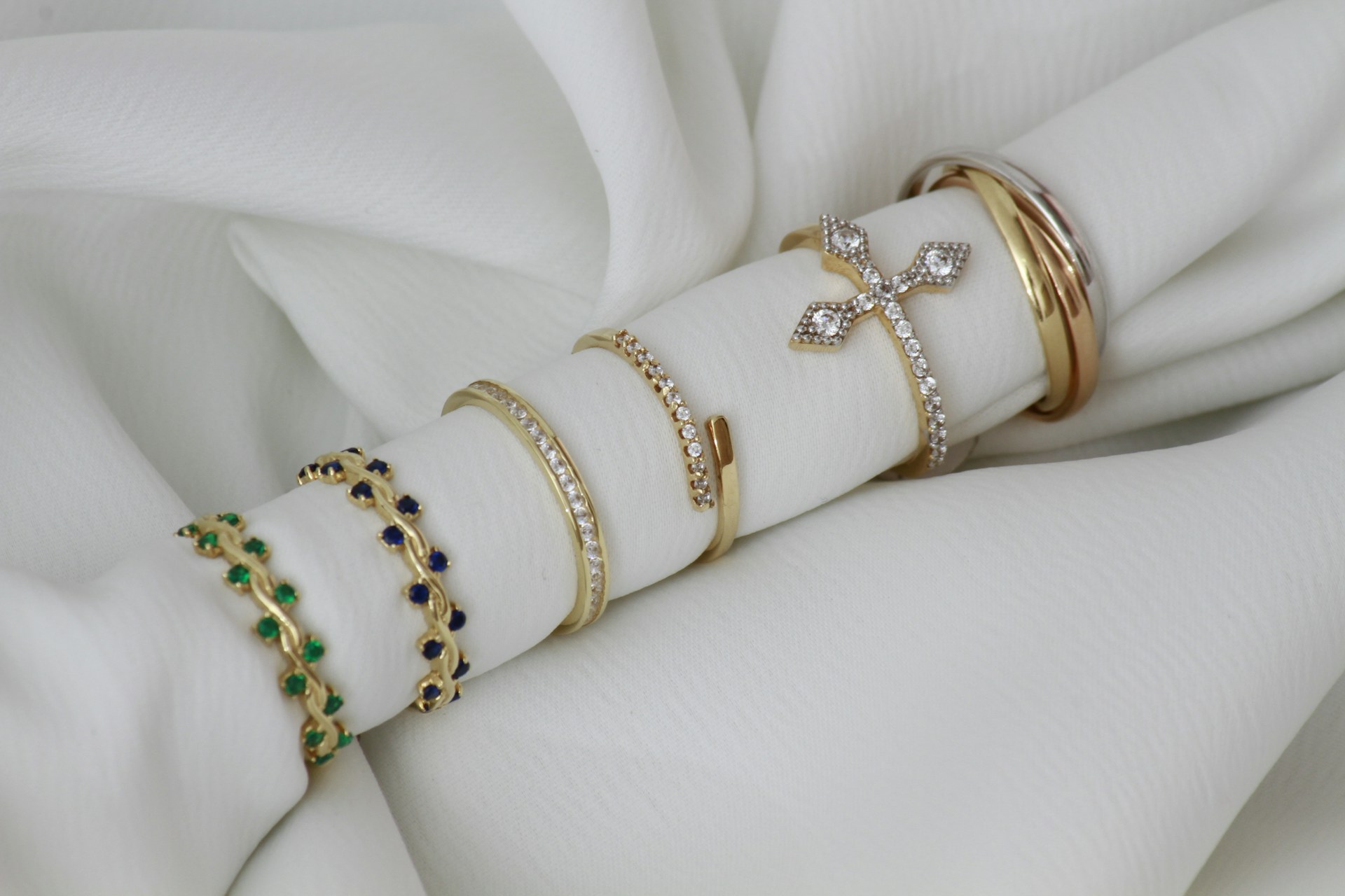 A close up of a stack of bracelets on a white cloth