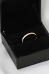 A black box with a gold ring inside of it