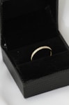 A black box with a gold ring inside of it