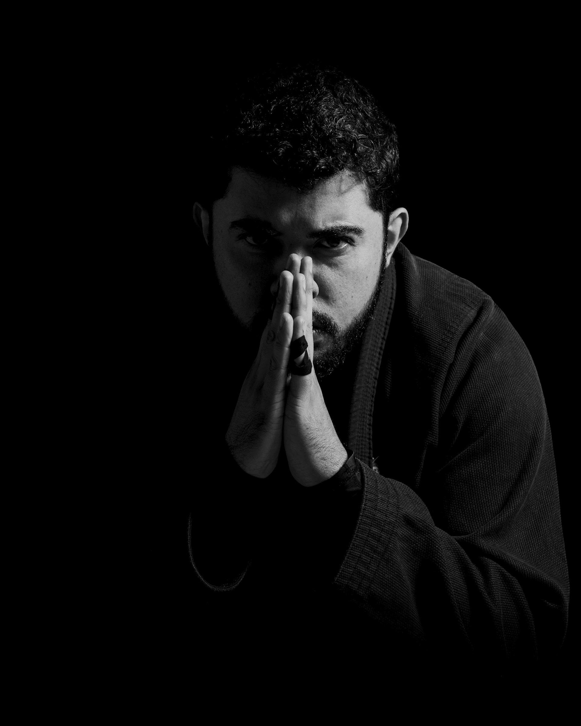A black and white photo of a man covering his face