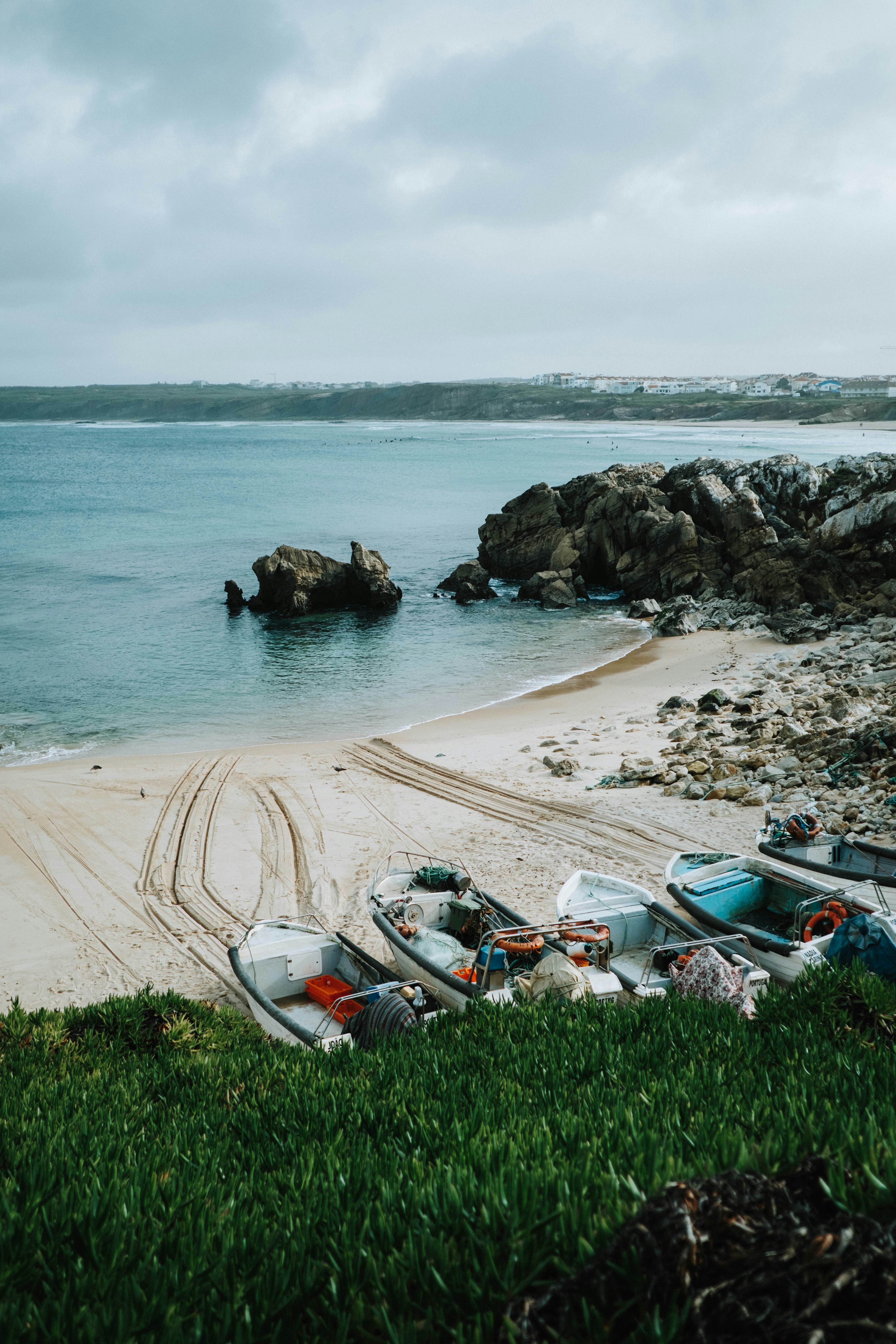 A group of boats sitting on top of a sandy beach