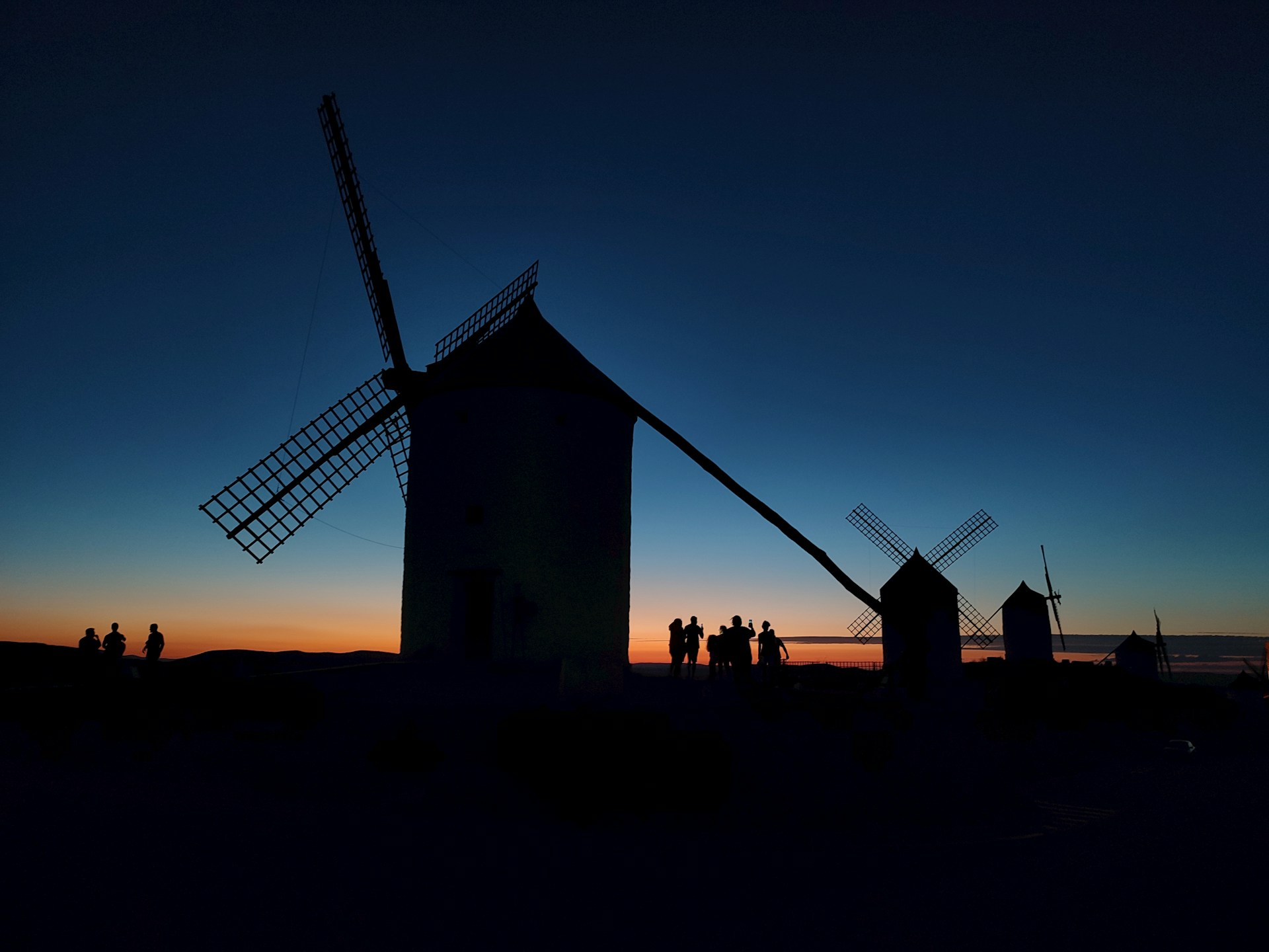 A windmill is silhouetted against a twilight sky