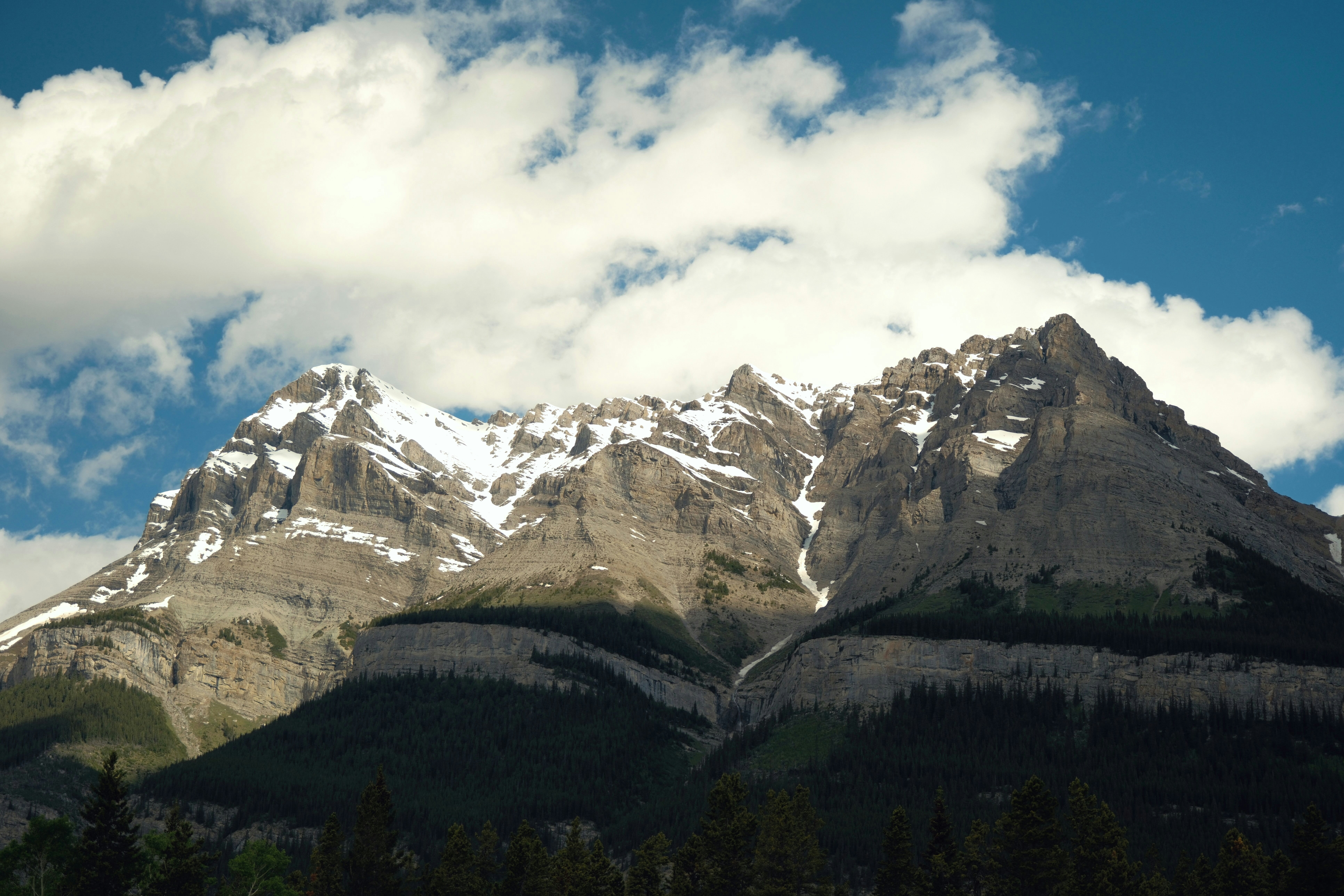 A mountain range with snow capped mountains in the background