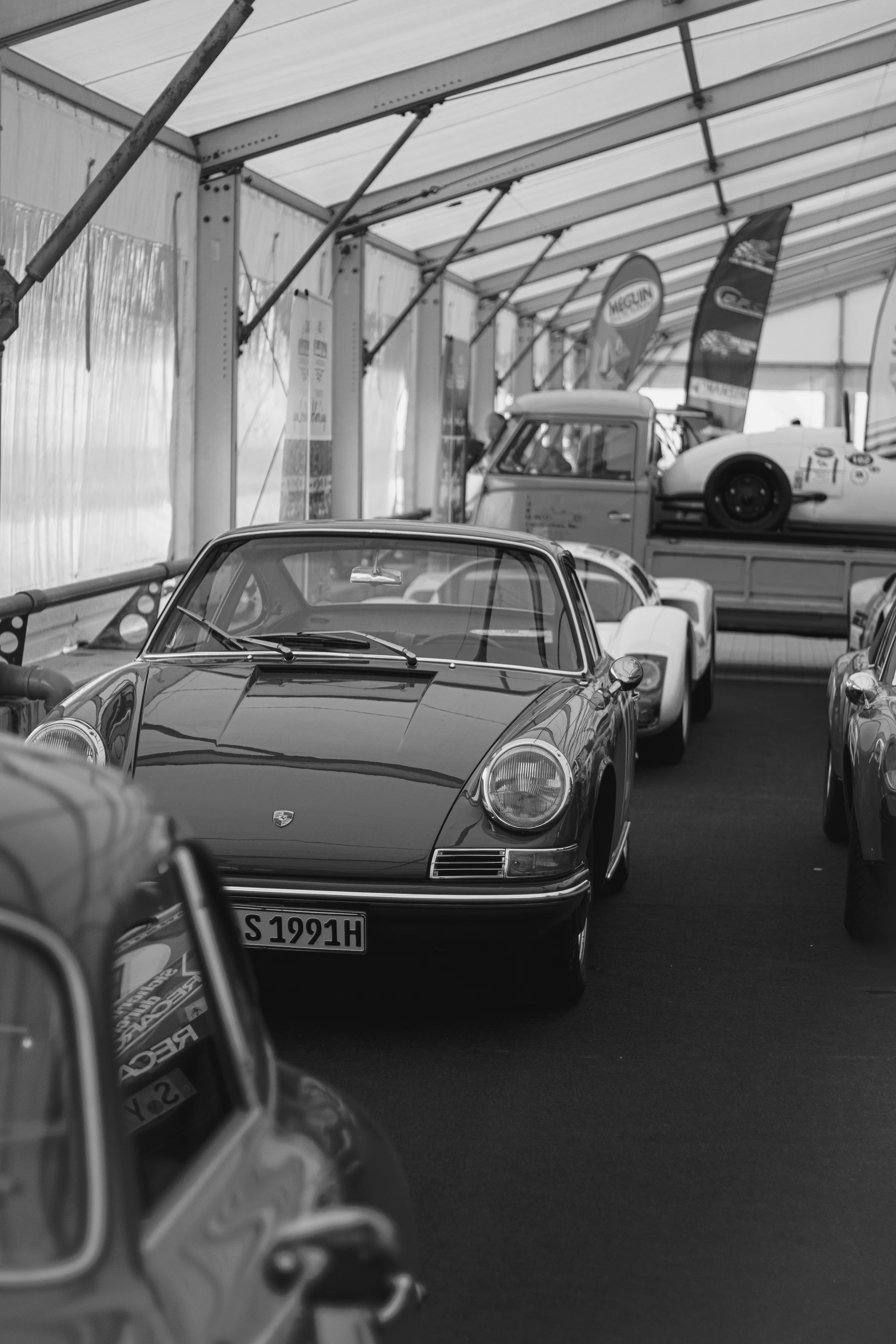 A black and white photo of cars parked in a garage