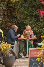 A couple of women sitting at a table outside
