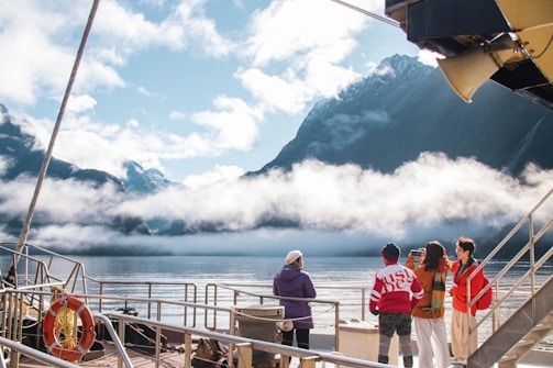 A group of people standing on top of a boat